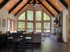Un loft amplio con ventanas grandes, una chimenea de piedra y un techo alto con vigas a la vista.