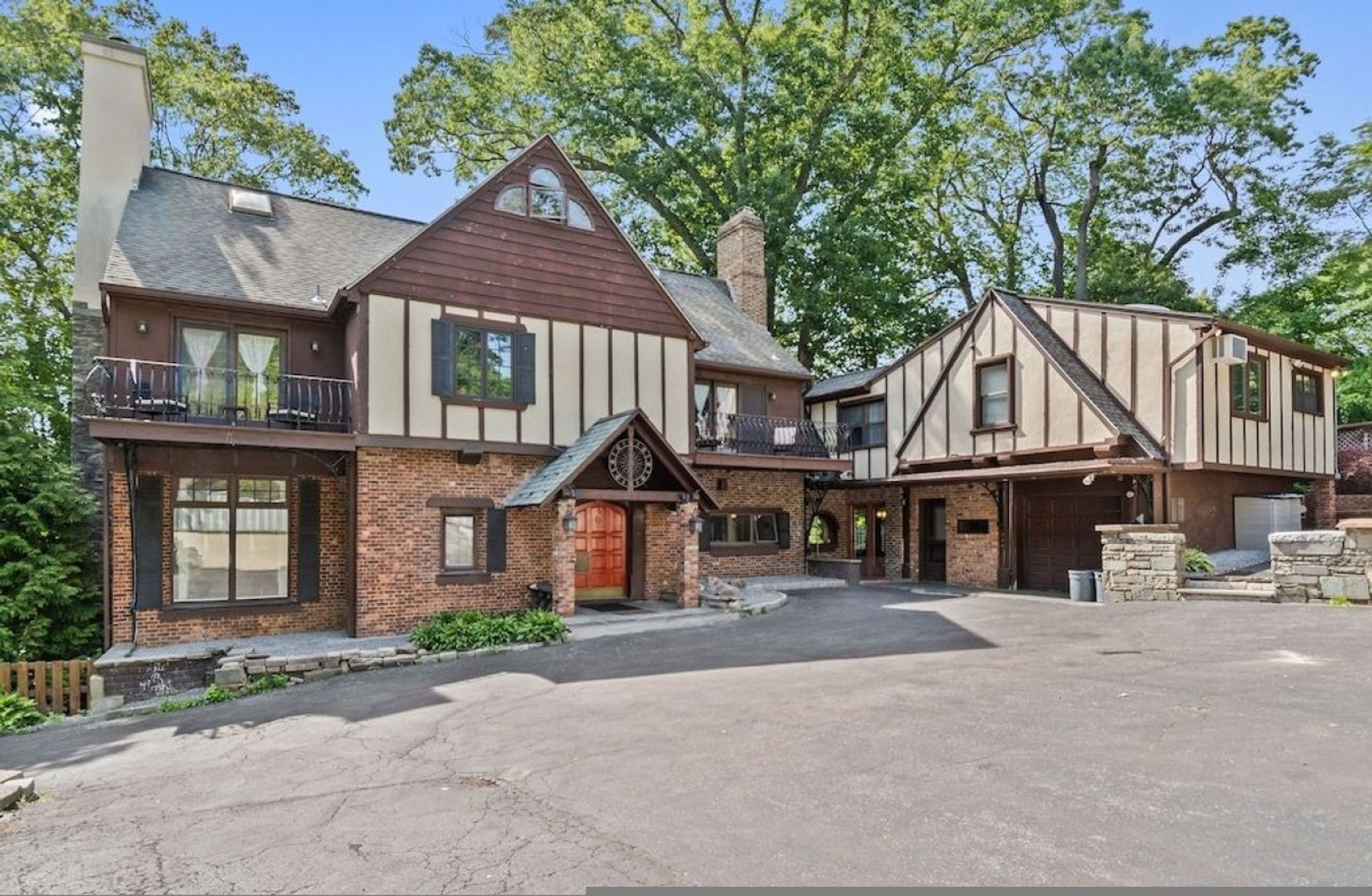 A two-story house with a garage, a covered porch, and a driveway.