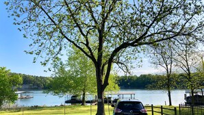 A car parked under a tree by a lake with a dock and a boat in the background. - 🌟Planetarium Treehouse🌟Stargazing Observatory with Beaver Lake Views (Springdale)