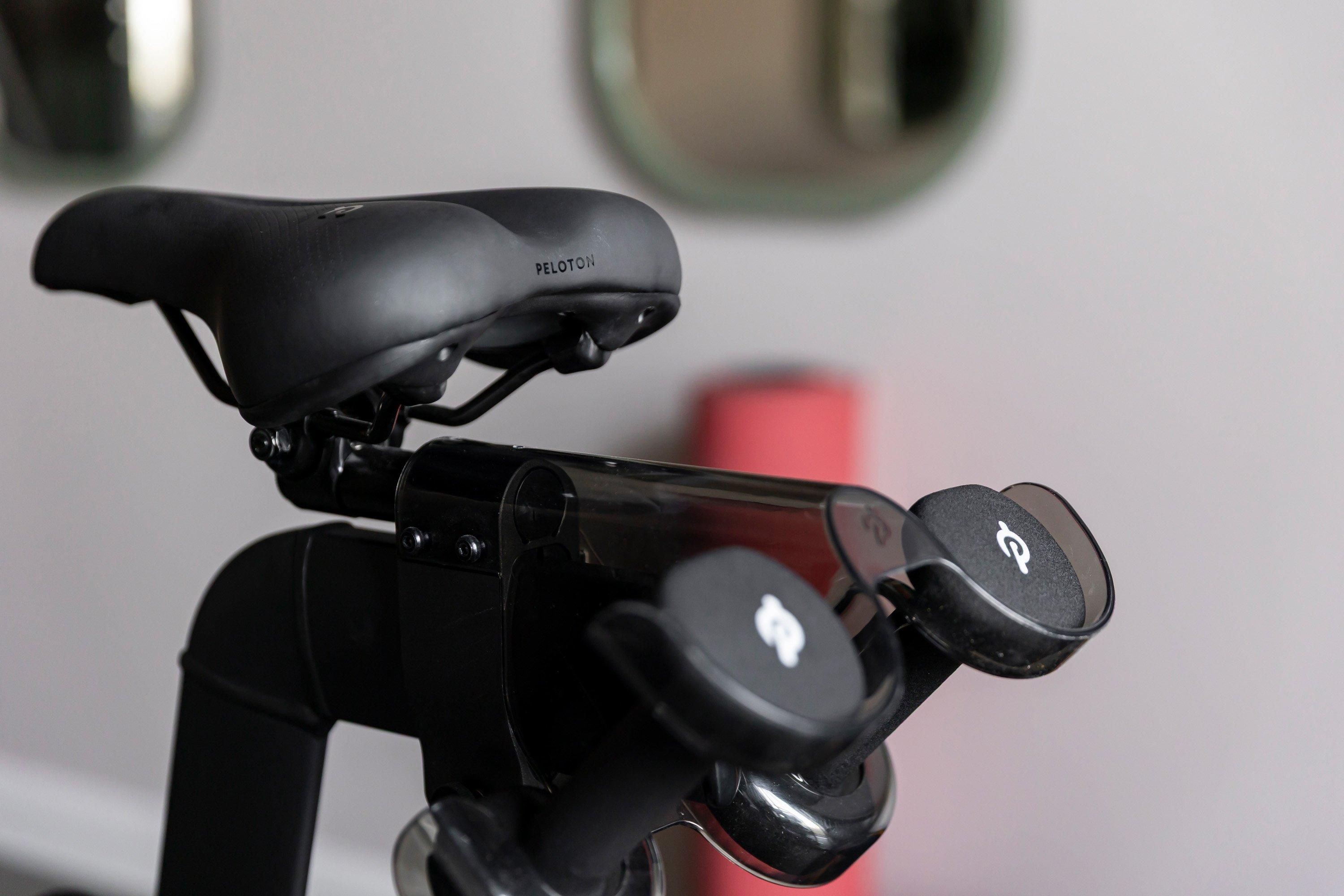 A bicycle with a Peloton seat and a handlebar with a G logo.