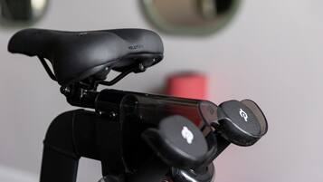 A bicycle with a Peloton seat and a handlebar with a G logo.