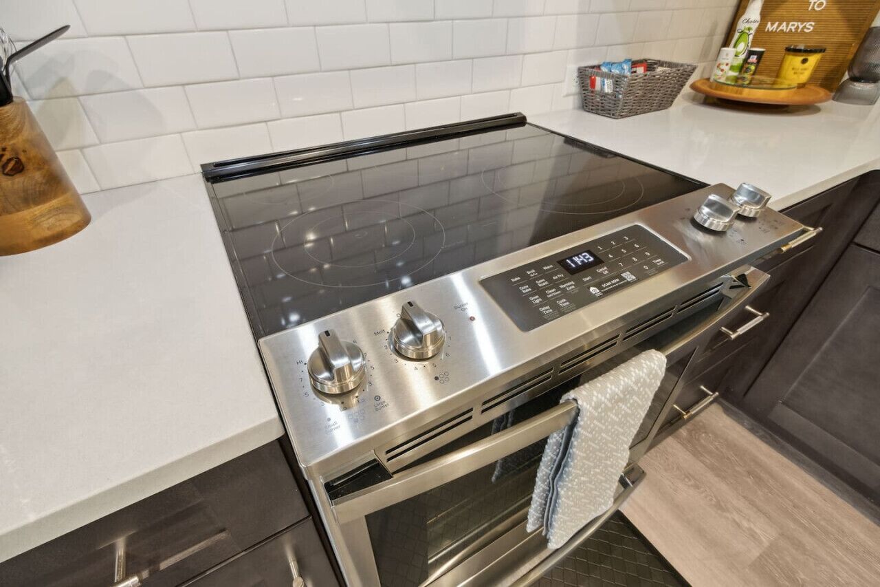 Une cuisine moderne équipée d’une cuisinière, d’un four et d’une hotte en acier inoxydable.