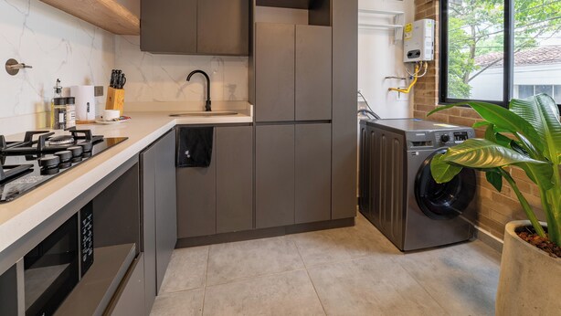 A modern kitchen with a built-in stove, sink, and dishwasher. - Ganesh by Wynwood House (Medellín)