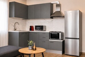A compact kitchen with grey cabinets, a stainless steel refrigerator, a microwave, and a toaster oven. - White Rodon Free Private Parking 3 Min to Beach

 (Chania)