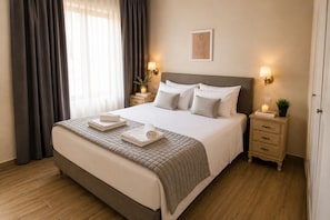 A neatly made bed with pillows, a bedside table with a lamp, and a framed picture on the wall.