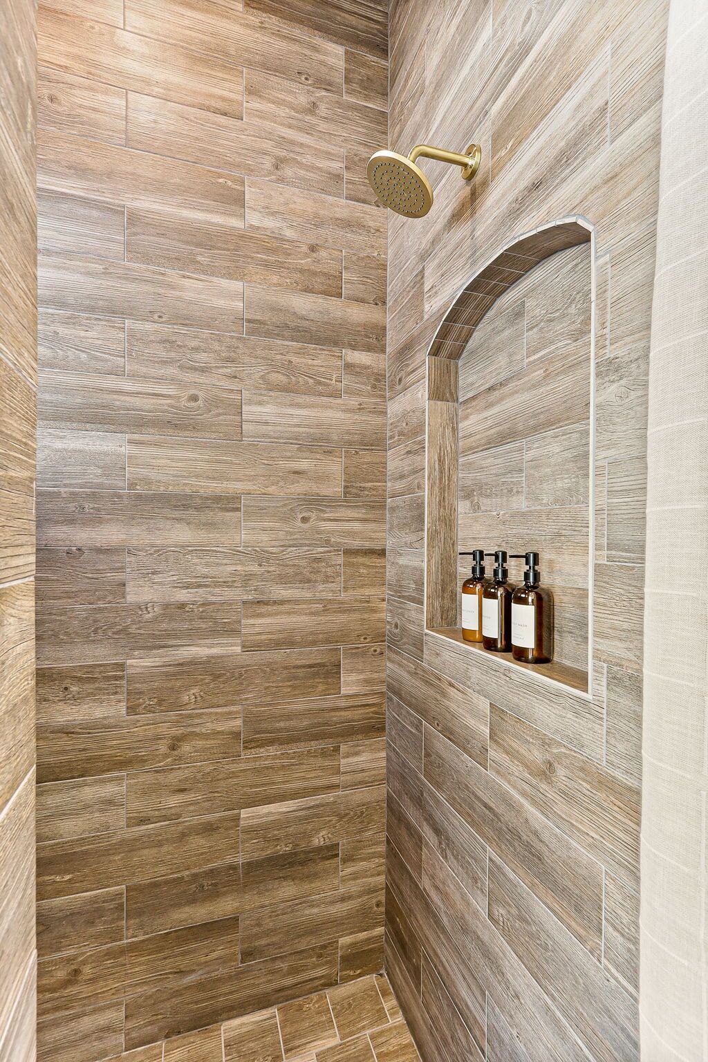 Un espace douche avec un mur décoré en bois et une pomme de douche.