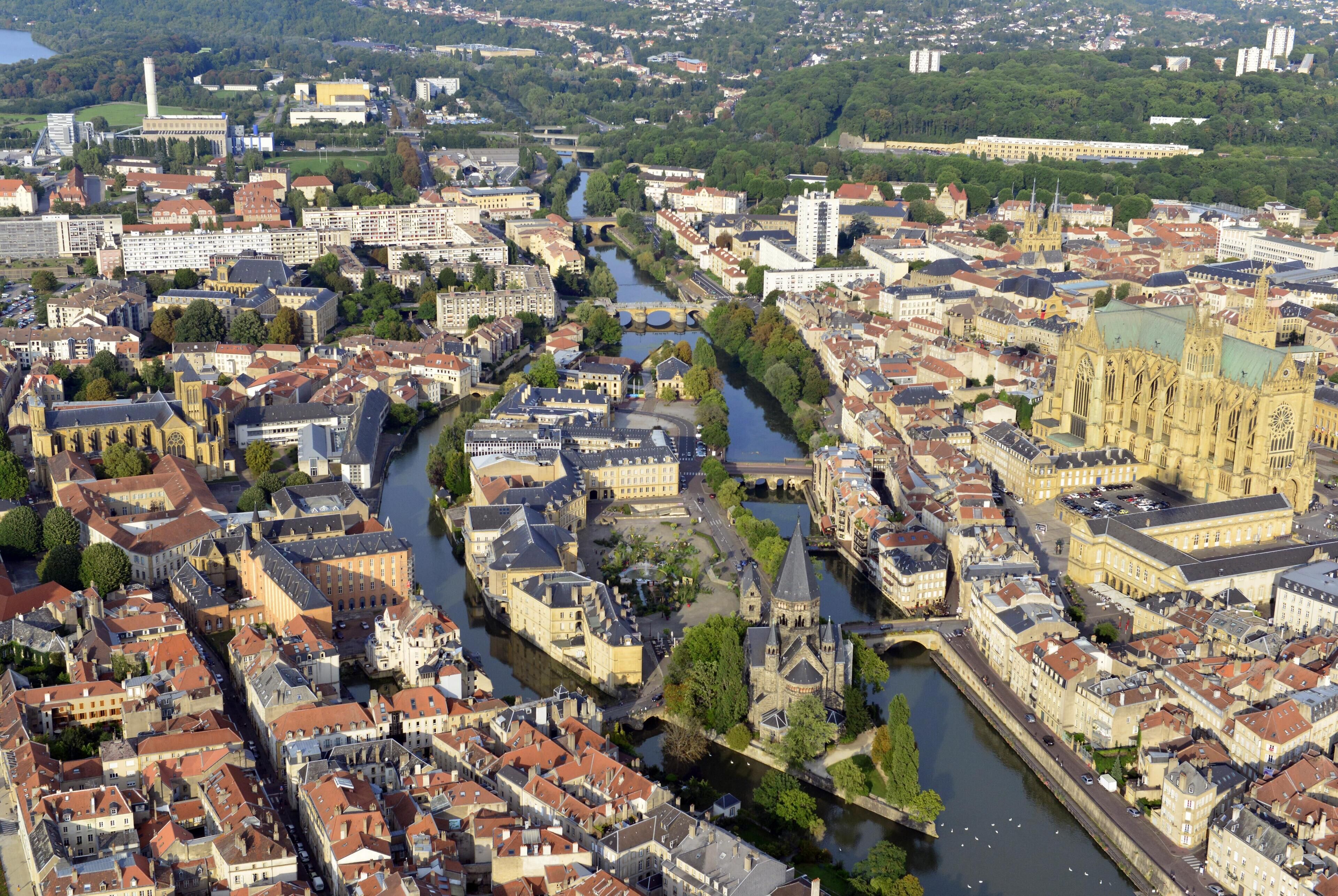 Un río atraviesa una ciudad con edificios históricos y una catedral destacada.