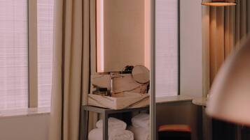 Une chambre d’hôtel comprenant un lit, une coiffeuse avec un miroir, un lavabo et une chaise.