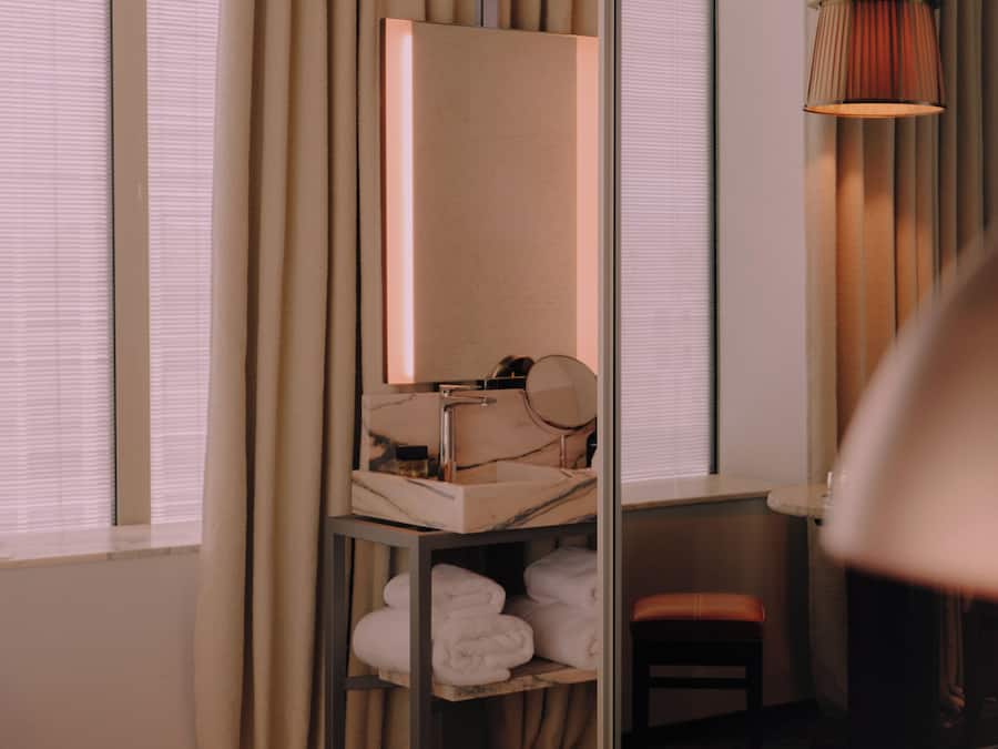 Une chambre d’hôtel comprenant un lit, une coiffeuse avec un miroir, un lavabo et une chaise.
