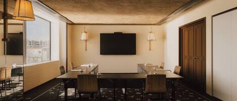 A conference room with a large table, chairs, and two wall-mounted lamps.