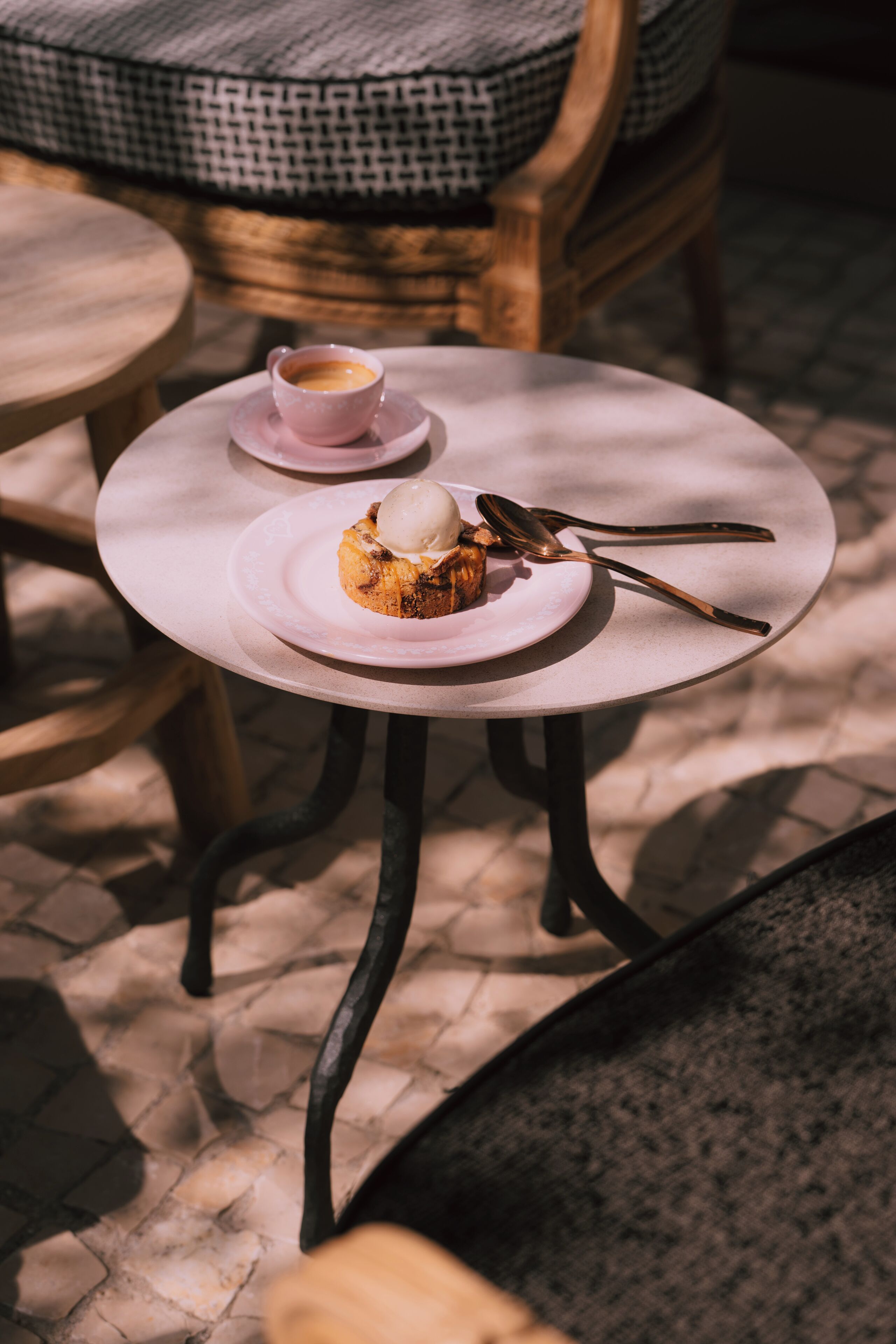 A round table with a plate of food and a cup of coffee.