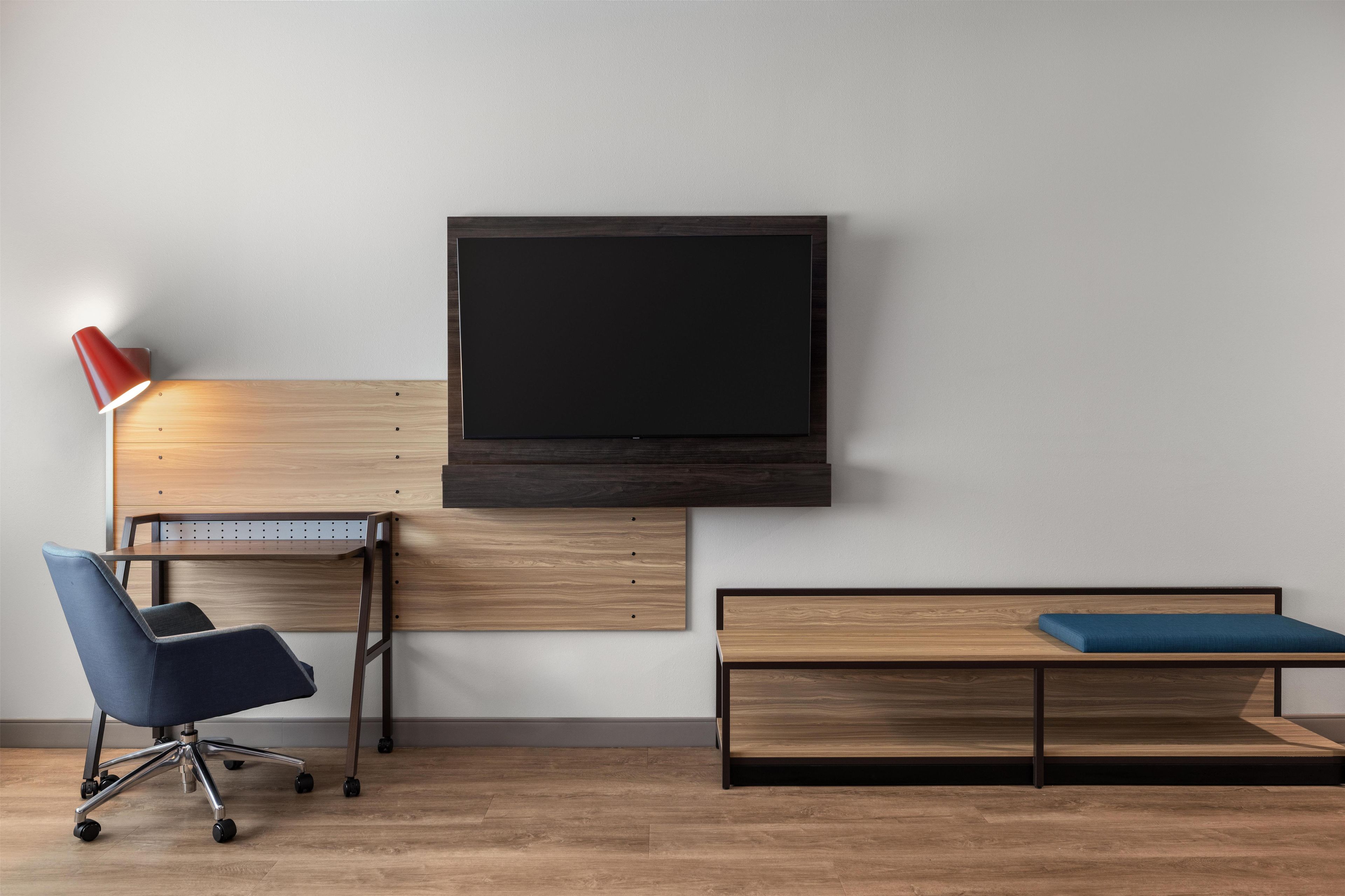 A modern office space with a desk, chair, and bench.