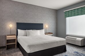 Une chambre d’hôtel avec un lit, des tables de chevet, un radiateur fixé au mur et une fenêtre donnant sur un paysage agréable.