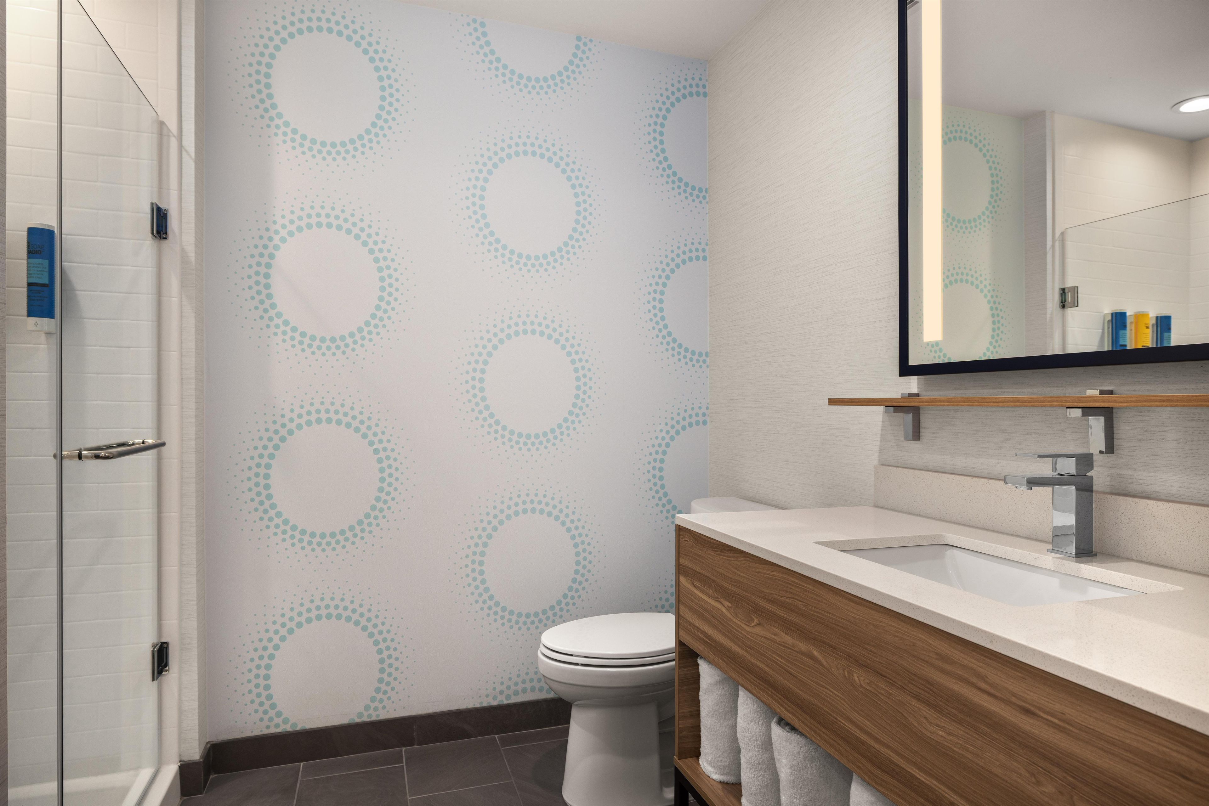 Ein modernes Badezimmer mit Duschkabine, Toilette und Waschtisch inklusive Spiegel.