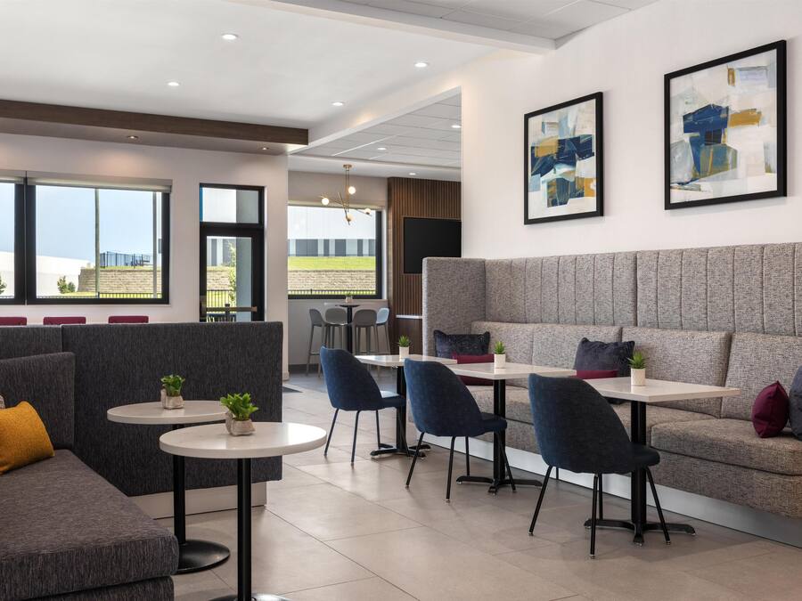 A modern lounge area with seating arrangements, including sofas and chairs, and a television screen.