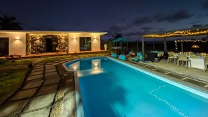 A modern house with a swimming pool, outdoor seating, and string lights. - Charming and cosy Villa in Bel Ombre (Bel Ombre.)