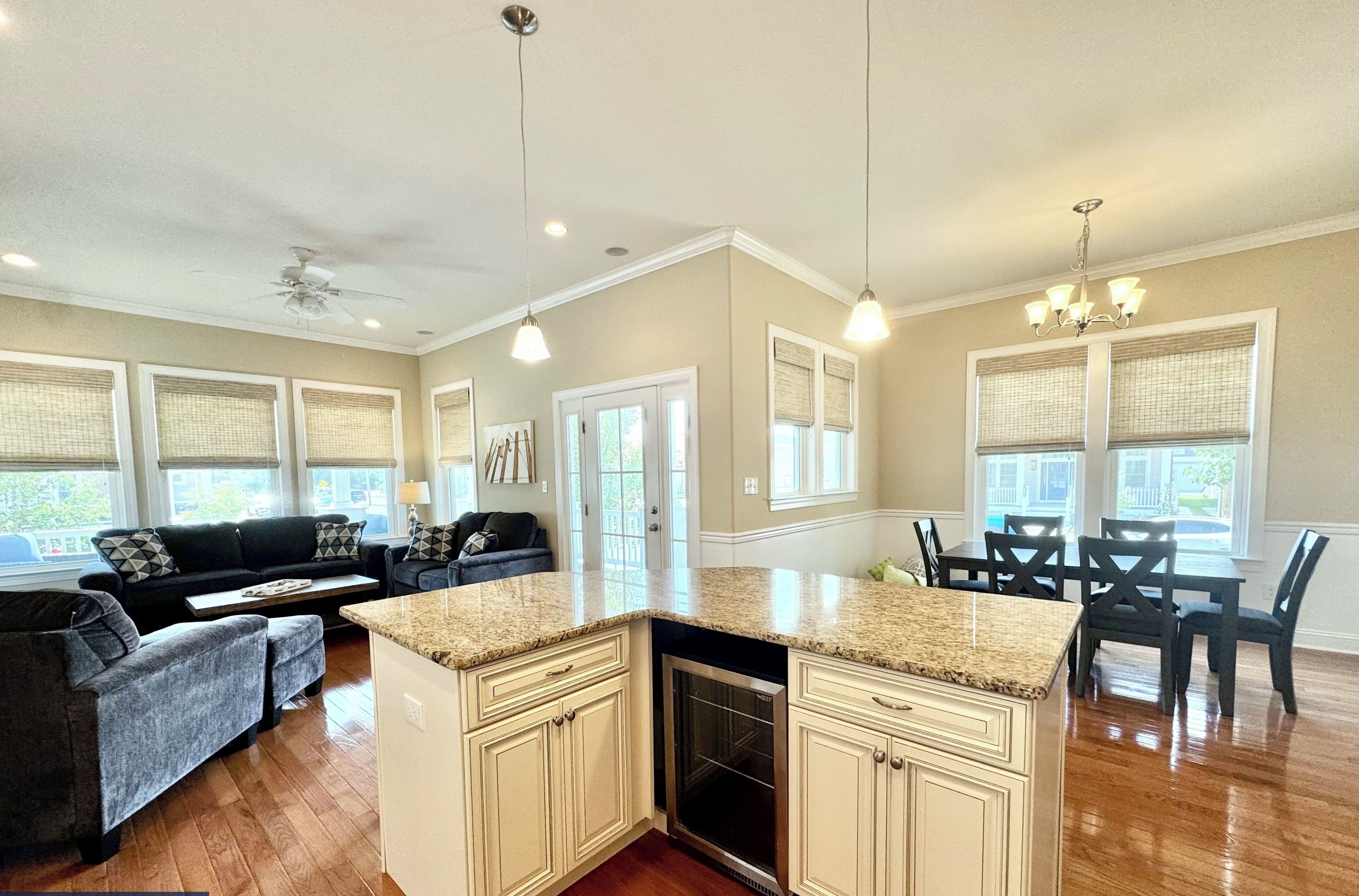 A spacious kitchen with granite countertops, a built-in dishwasher, and a dining area with a table and chairs.