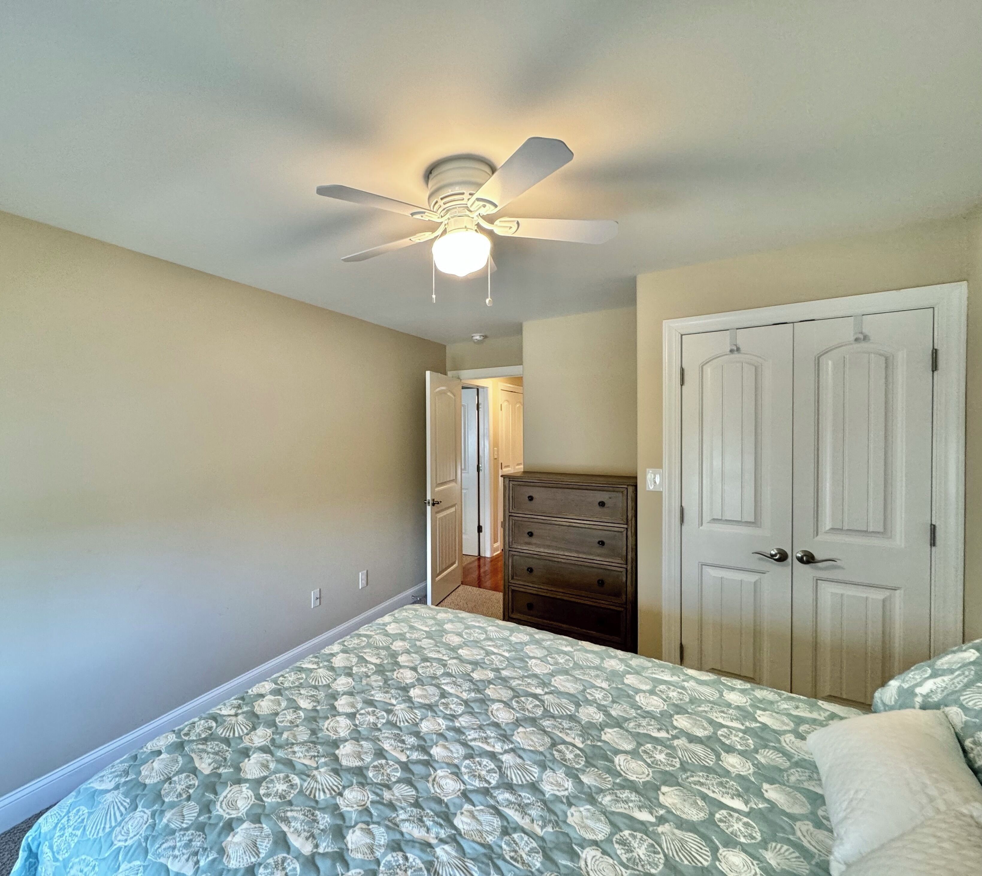 A bedroom with a bed, dresser, and wardrobe.