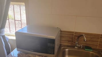 Full-sized fridge, microwave, stovetop, cookware/dishes/utensils