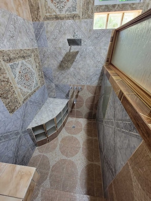 Un baño con ducha semicircular, lavabo y bañera.