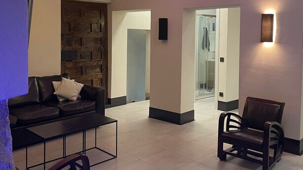 A modern living room with a black leather sofa, a wooden coffee table, and a dining area with a black chair. - 7 beds, 3bedR, Centro, SOL, Gran Via, metro Noviciado, Callao (Madrid)