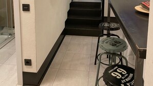 A modern kitchen with a dining area, a staircase, and a hallway leading to another room. - 7 beds, 3bedR, Centro, SOL, Gran Via, metro Noviciado, Callao (Madrid)