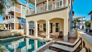 Ein Poolbereich mit Liegestühlen und einer überdachten Terrasse.