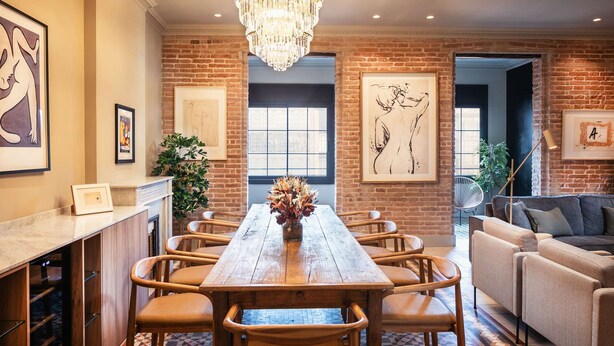 A dining area with a wooden table and chairs, a chandelier, and artwork on the walls. - Lovely 6 BR Flat in L Eixample (Barcelona)