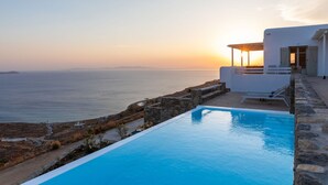 A modern hotel with a pool overlooking the sea, stone walls, and a clear view of the horizon. - Renovated Luxury Oceanview Villa With Pool in Mykonos (Mykonos)