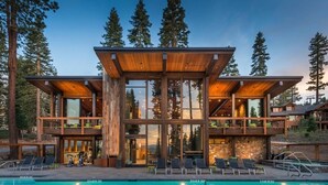 A modern multi-level wooden cabin with a pool, surrounded by tall trees. - Modern Ski In Out Home Mid-mountain Northstar (Truckee)