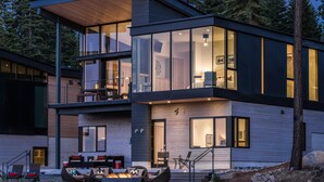 A modern two-story house with large windows, a balcony, and a fire pit in the front yard. - Modern Ski In Out Home Mid-mountain Northstar (Truckee)