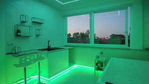 A modern kitchen with a window, bar stools, and a sink. - B&B LA PERLA NERA (Fasano)