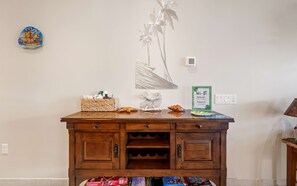 A wooden cabinet with a glass top, a decorative wall piece, and a Wi-Fi sign.