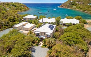 A coastal property with multiple houses, a beach, and boats in the water. - The Pirate's Landing North - St. John USVI - Chocolate Hole (Cruz Bay)