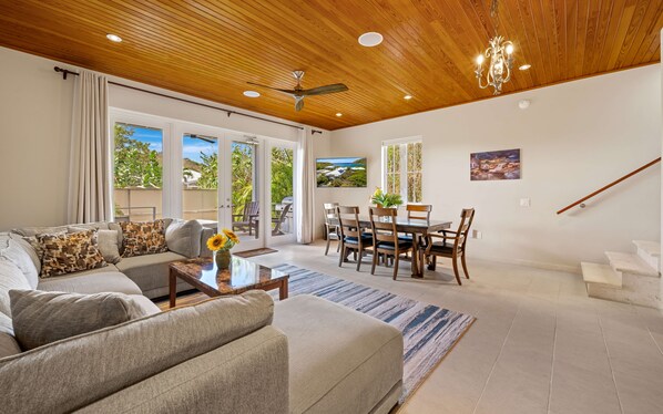 A spacious living room with a sofa, coffee table, and dining area.