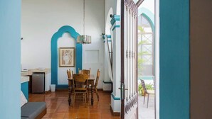 A dining area with a table and chairs, a refrigerator, and a window with a view of the outside. - Unique Suite Historic Center Terrace WIFI+Desk+AC (Santiago de Querétaro)