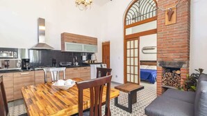 Une cuisine moderne avec un coin repas, une cheminée et un canapé.