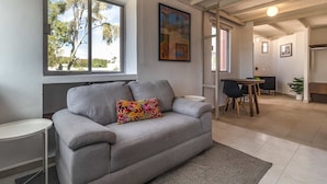 A living room with a grey sofa, a colorful pillow, a dining table with chairs, and a painting on the wall. - Huge apartment, top location w/terrace. 4bd 3.5ba (Santiago de Querétaro)