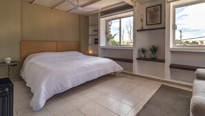 A bedroom with a large bed, a ceiling fan, a window with a view, and built-in shelves. - Huge apartment, top location w/terrace. 4bd 3.5ba (Santiago de Querétaro)