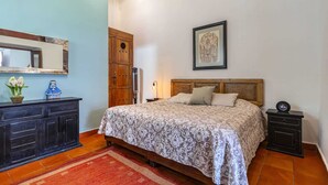 A bedroom with a bed, dresser, nightstand, and a framed picture on the wall. - Suite on main street in Historic Downtown WIFI (Santiago de Querétaro)