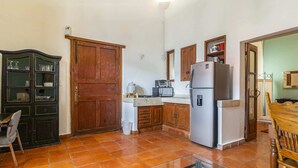 A compact kitchen with a refrigerator, microwave, and stove. - Suite on main street in Historic Downtown WIFI (Santiago de Querétaro)