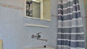 A bathroom with a sink, mirror, and striped shower curtain. - Apartments Jug - Comfort Studio Apartment with Balcony (Lopar)