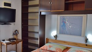 A bedroom with a bed, a desk, a TV, and a painting. - Apartments Jug - Comfort Studio Apartment with Balcony (Lopar)