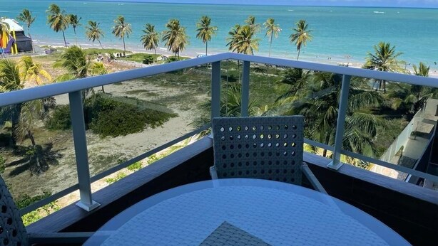 A balcony with a view of the beach and palm trees. - Pé na Areia em Ponta de Campina, Paraíba (Cabedelo)