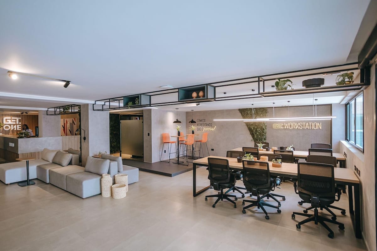 A modern office space with a reception area, a meeting room, and a lounge area with a sofa and chairs.
