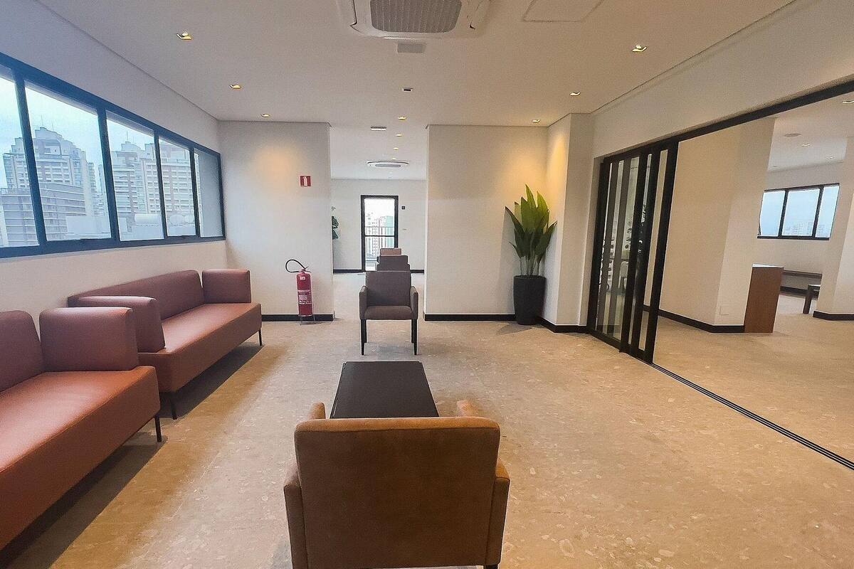 A modern waiting area with a sofa, chairs, a small table, and a potted plant.