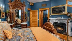 A bedroom with a large bed, a fireplace, and a wooden wardrobe. - Two-bedroom Penthouse with rooftop BBQ, dining & hot tub. (Hood River)