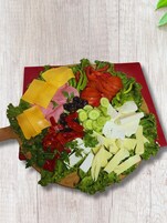 Una tabla de madera con una variedad de verduras frescas y rebanadas de queso.