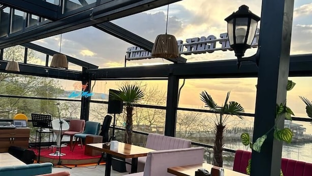 Een terras met tafels en stoelen, een podium en een uitzicht op de stad.