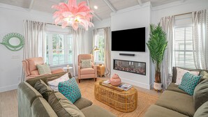 Ein Wohnzimmer mit Kamin, Fernseher und einer großen Pflanze.